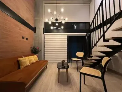 a living room with a couch and a staircase at Hermoso Loft in Medellín