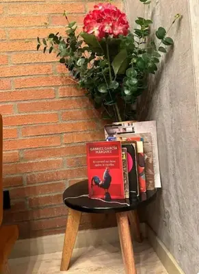a table with a book on it next to a brick wall at Loft hermoso y céntrico 1109 in Medellín