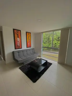 a living room with a couch and a large window at Apartamento Urban Manizales in Manizales