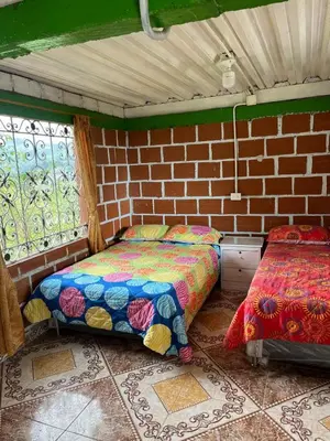 a room with two beds and a brick wall at Coffee Tour, Colombia Aranzazu Caldas- Andean Motmot coffee in Aranzazu