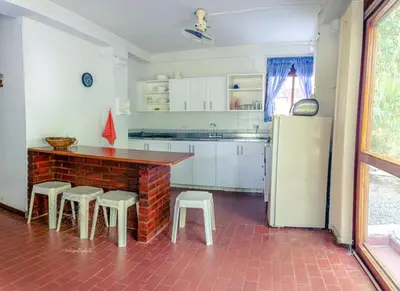 a kitchen with a table and stools and a refrigerator at Apartamento Campestre La Florida in La Florida