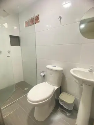 a white bathroom with a toilet and a sink at S21 COMODO APARTAMENTO EN LAURELES ESTADIo 2 HABT 2 BAÑOS in Medellín