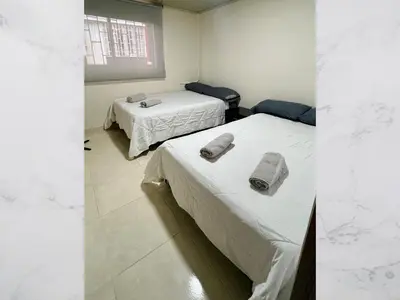 two beds in a room with towels on them at Hospedaje Gladys in Manizales