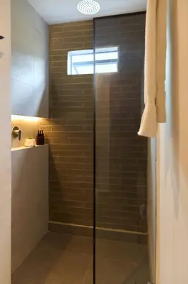 a shower with a glass door in a bathroom at Cozy Comforts at Rosa Negra Stadio in Medellín