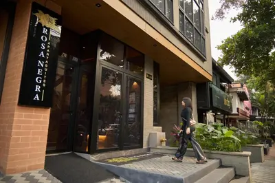 a man walking in front of a store at Stadio Aparta-Suite Bliss Rosa Negra in Medellín