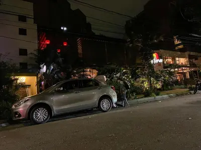 a silver car parked on the side of a street at night at Stadio Aparta-Suite Bliss Rosa Negra in Medellín