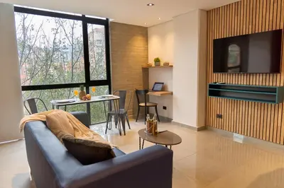 a living room with a couch and a table at Inviting Stadio Suite Rosa Negra in Medellín
