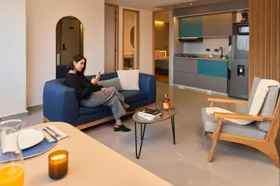 a man sitting on a blue couch in a living room at Cozy Stadio Escape Rosa Negra Stay in Medellín