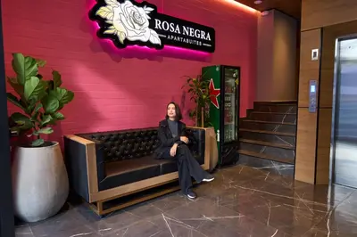 a woman sitting on a bench in the lobby of a hotel at Cozy Stadio Escape Rosa Negra Stay in Medellín