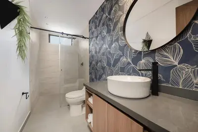 a bathroom with a sink and a toilet and a mirror at Apt in el Poblado, walkable area with parking 215 in Medellín