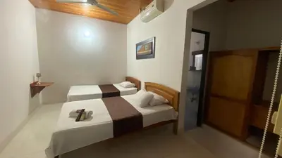 a hotel room with two beds and a sliding door at Hotel kerana moon in Puerto Boyacá