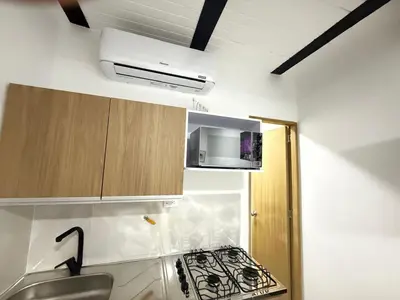 a small kitchen with a stove and a sink at Casa Bendita - Aparta estudio 104 in Medellín