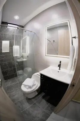 a bathroom with a toilet and a sink and a mirror at Live the Comuna 13 experience in Medellín INT 304 in Medellín