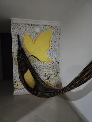 a hammock in front of a wall with a painting at Habitación con sofacama - apto compartido in Envigado