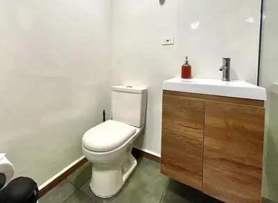 a bathroom with a white toilet and a sink at 43 Laureles Life I Modern Loft and Excellent Location in Medellín