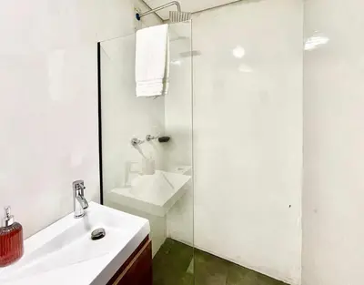 a white bathroom with a sink and a shower at 43 Laureles Life I Modern Loft and Excellent Location in Medellín