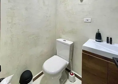 a bathroom with a white toilet and a sink at 43 Laureles Life I Modern Loft and Excellent Location in Medellín