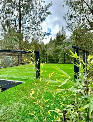 a view of a tennis court with green grass at Finca 5 Continentes - Cerca MatroCable ARVI in Guarne