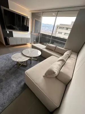 a living room with a couch and a large window at Apartamento en Medellín poblado in Medellín