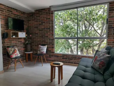 a living room with a couch and a brick wall at Medellin- La 70, close to everything, Laureles retreat in Medellín