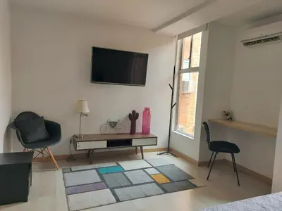 a living room with a television and a table and chairs at Medellin- La 70, close to everything, Laureles retreat in Medellín