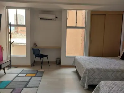 a bedroom with two beds and a desk and two windows at Medellin- La 70, close to everything, Laureles retreat in Medellín