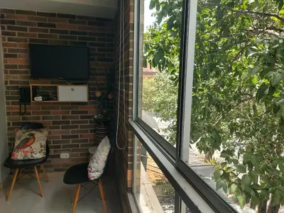 a living room with a window and a television at Medellin- La 70, close to everything, Laureles retreat in Medellín