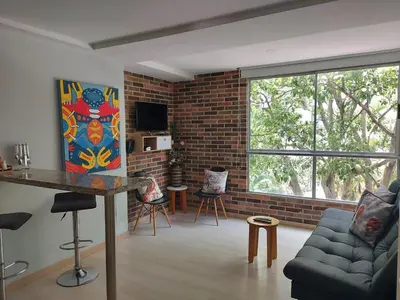 a living room with a couch and a brick wall at Medellin- La 70, close to everything, Laureles retreat in Medellín