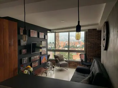 a living room with a couch and a large window at Stylish Loft in Laureles-Gorgeous views & comfort in Medellín