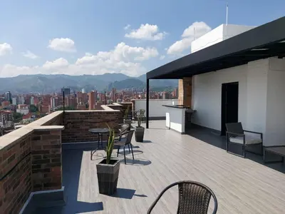 a rooftop deck with chairs and tables on a building at Penthouse Rooftop terrace Gem in the sky-Laureles in Medellín
