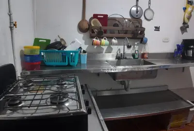 a kitchen counter with a sink and a stove at Casa de pesca in Honda