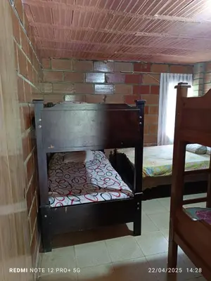 a bed in a room with a brick wall at Finca Arcanos Celeste in Barbosa