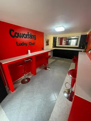 a waiting room with a red counter and red stools at Hotel boutique san pablo H5 in Medellín