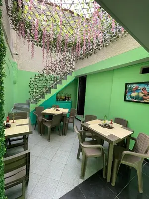 a restaurant with tables and chairs and a ceiling with flowers at Hotel boutique san pablo H5 in Medellín