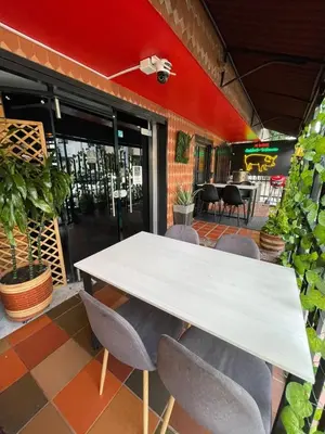 a white table and chairs in front of a restaurant at Hotel boutique san pablo H5 in Medellín