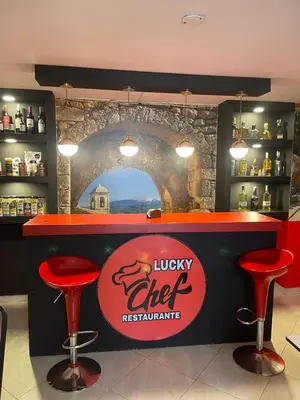 a bar with two red stools and a lucky chef restaurant at Hotel boutique san pablo H4 in Medellín