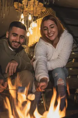 a man and a woman sitting around a fire at MORITZ By MONTE GANDOLFO in Chiquinquirá
