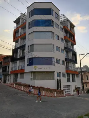 a tall building with people walking in front of it at Vancouver 102 in Villamaría