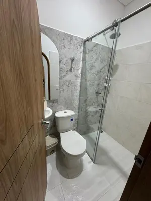 a bathroom with a toilet and a glass shower at Habitaciones en Doradal 202 in Doradal