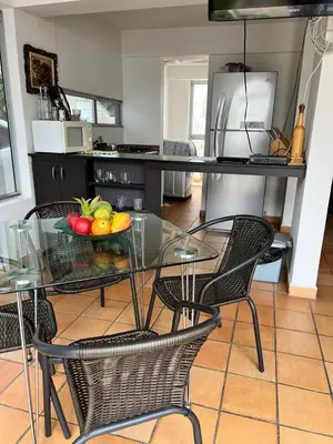 a glass table with a bowl of fruit on it in a kitchen at Cabaña ciudadela premium San Jerónimo in San Jerónimo