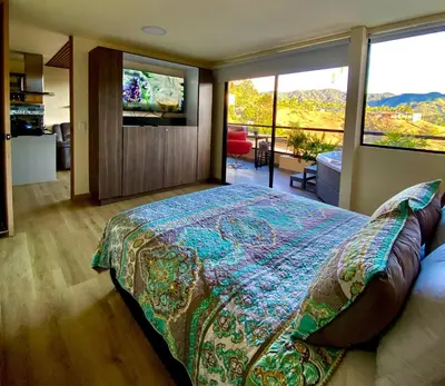 a bedroom with a bed and a large window at San Telmo - Guatape with Hot Tube in Guatapé