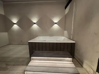 a bath tub in a room with lights on the wall at 5BR Poblado House to close LlerasPark Jacuzzi AC in Medellín