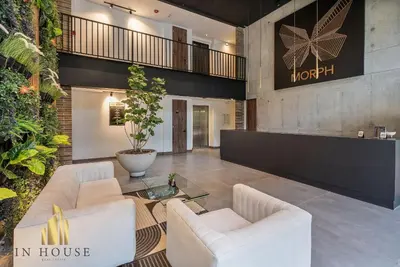 a lobby with two white chairs and a table at Morph 1002 - Luxe apt in Poblado/AC/BBQ in El Poblado