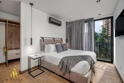 a bedroom with a bed and a large window at Morph 502 - Bright & Spacious, Poblado/BBQ/Jacuzzi in El Poblado