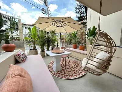a patio with a chair and a table and an umbrella at Large Apt-Laureles-Smart Lock-AC-Laundry Service in Medellín