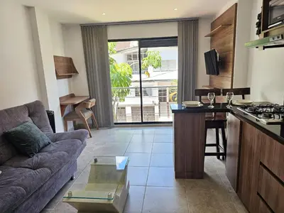 a kitchen and living room with a couch and a table at Apto Confortable en Zona Exclusiva de Laureles Medellín 401 Tranquilidad y cerca a todo in Medellín