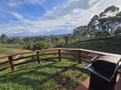 a barbecue grill sitting on top of a wooden fence at Luxurious country cabin, BBQ, Jacuzzi, TV, WiFi in Marinilla