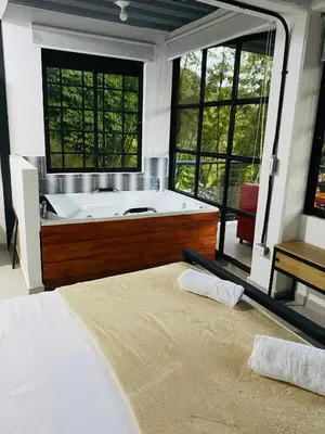 a large bathroom with a tub and a bed at Hotel Curazao Natural Living cerca a charcos naturales y tobogán extremo in Cocorná
