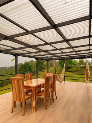 a wooden dining table and chairs under a pergola at Apartamento en Guarne-Antioquia in Guarne