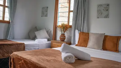 a hotel room with two beds and a window at Casa de 7 habitaciones cerca al pueblo de Guatapé in Guatapé